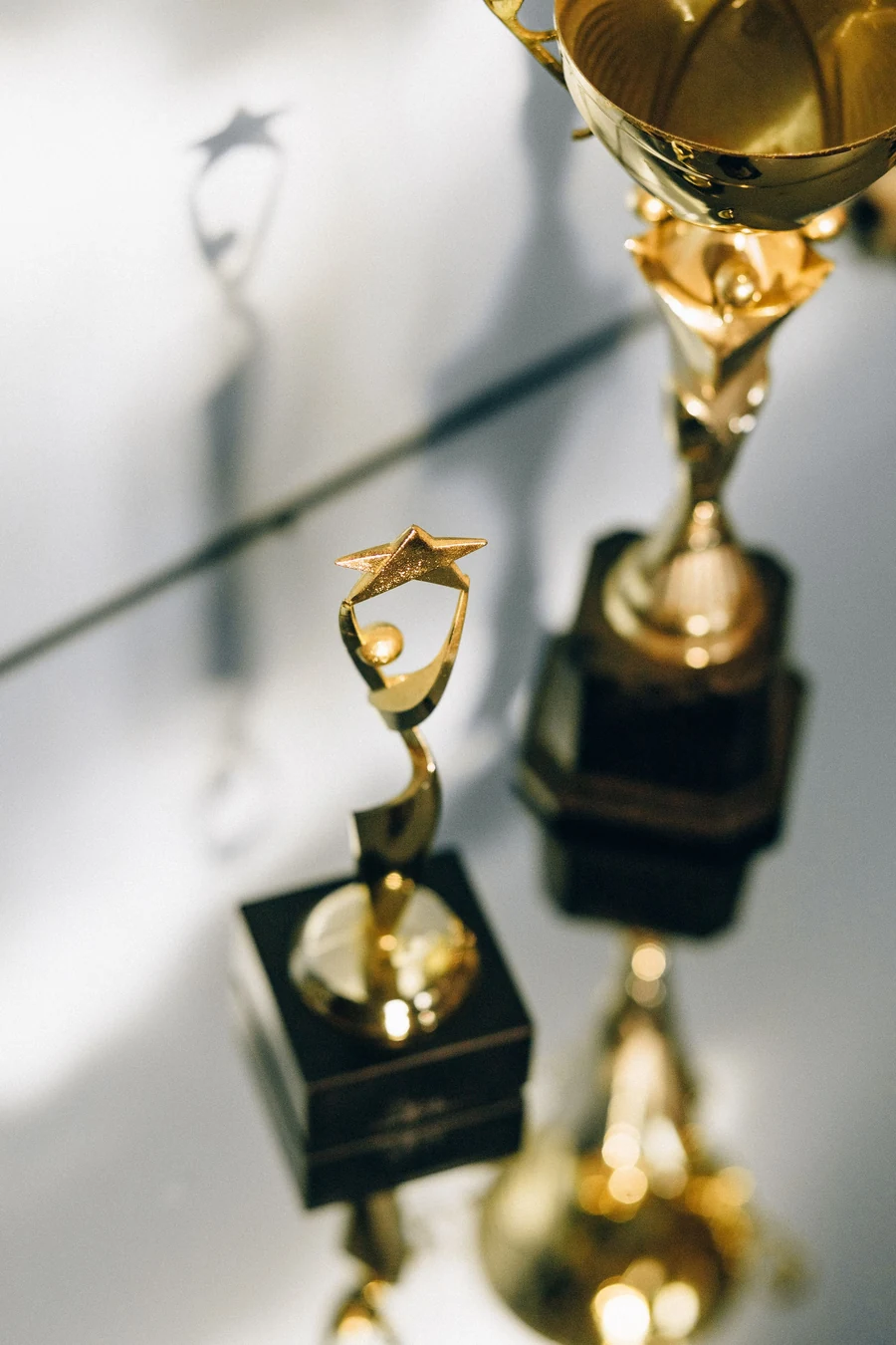 Illustrative gold recognition trophies in a softly lit arrangement