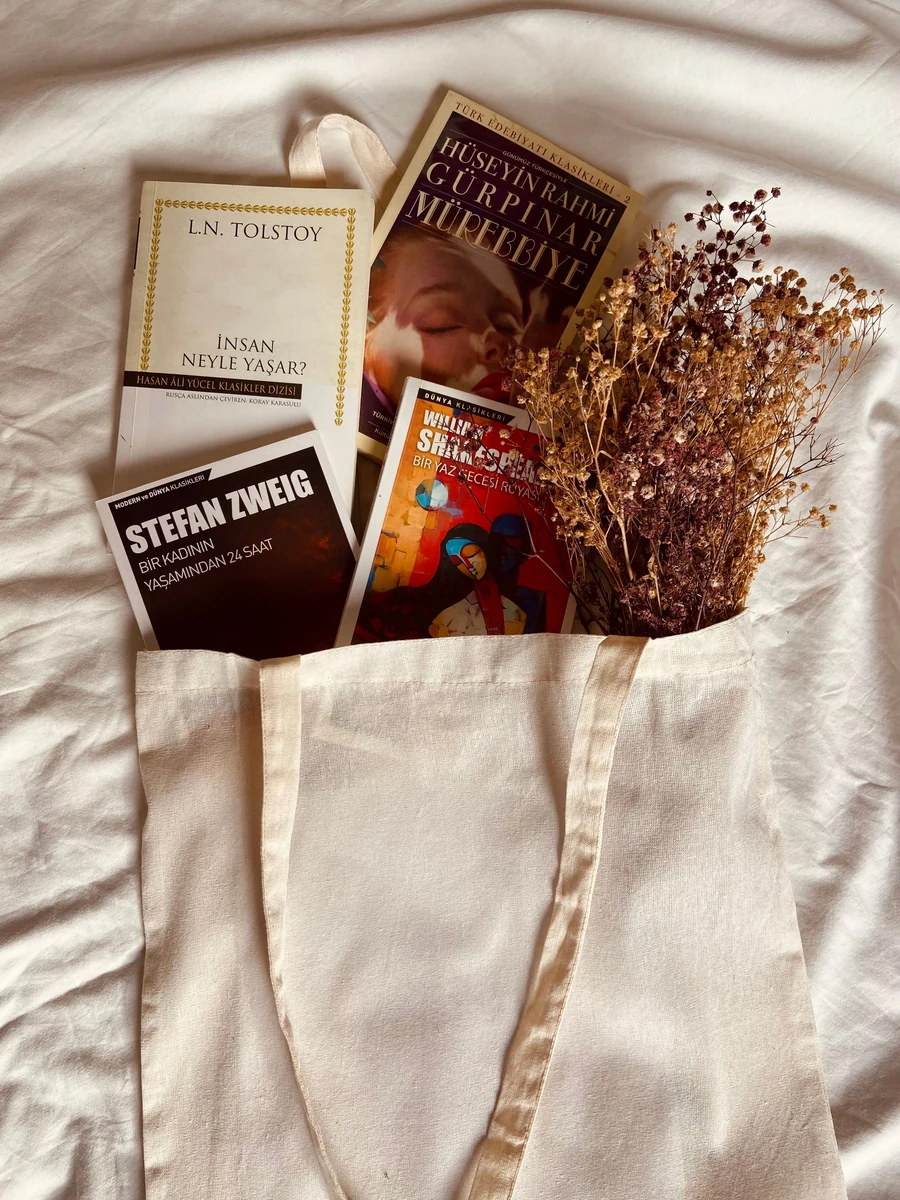Illustrative reusable canvas tote with books and dried flowers