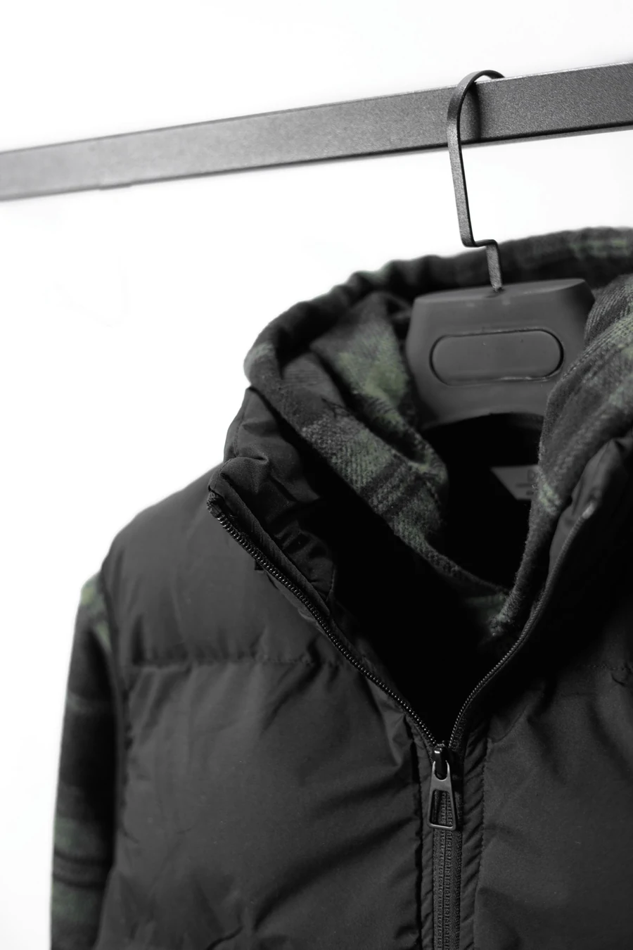 Illustrative black jacket on a hanger in a minimal setting